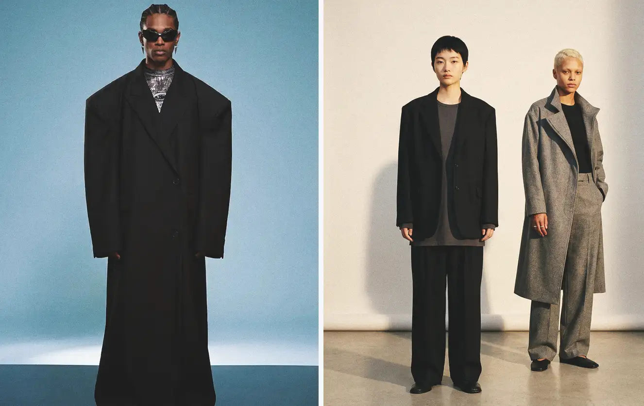 Avant-garde clothing silhouettes featuring an extreme oversized black wool maxi coat with exaggerated shoulders — paired with two models wearing deconstructed oversized blazers, wide-leg trousers and a grey longline coat in a clean editorial setting