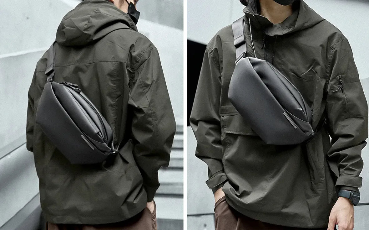 man in olive green techwear jacket wearing crossbody bag