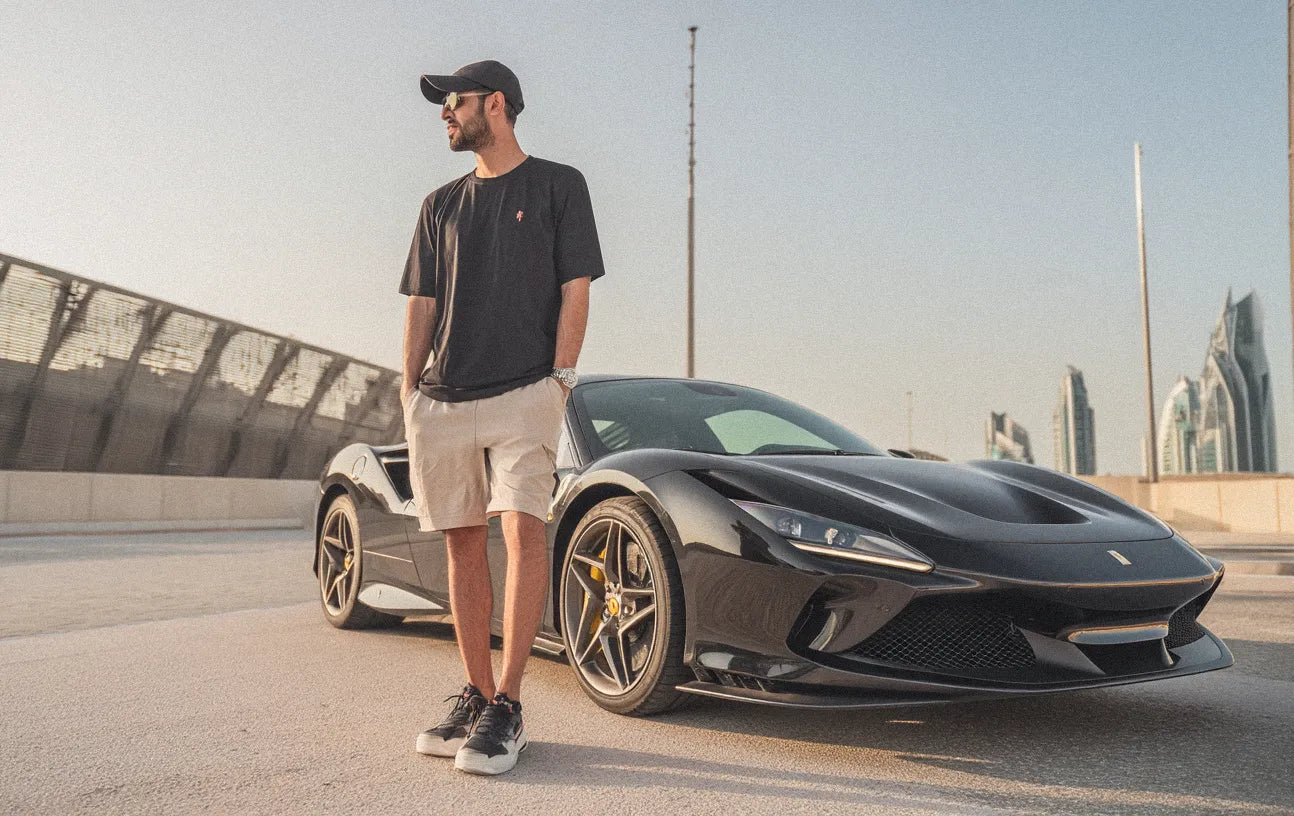 a man in front of a black ferrari