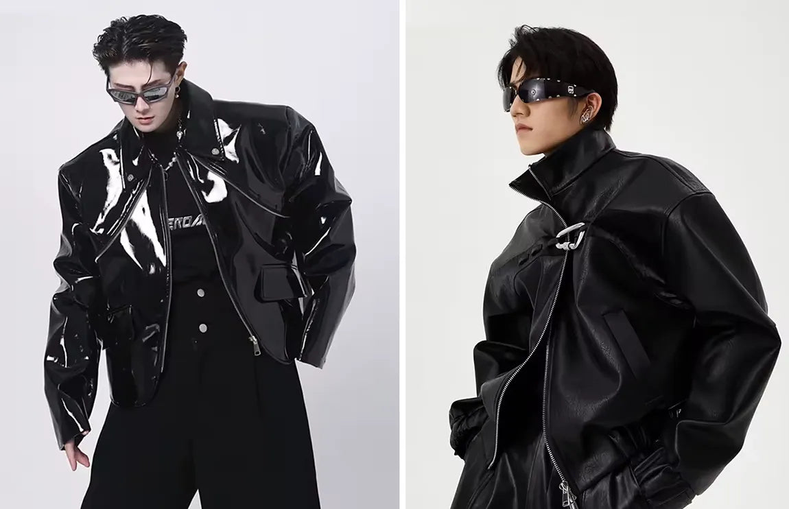 Two models in futuristic, shiny black opium clothing jackets, one with white piping and the other a leather jacket with a unique silver clasp.